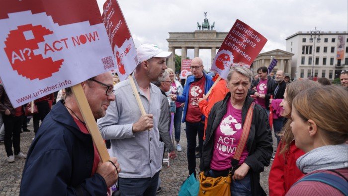 Members of an authors’ rights group call for AI regulation at a rally in Berlin. To date, regulators and lawmakers have failed to grasp the full dimensions of the challenge